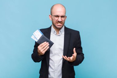 Genç kel adam sinirli, sinirli ve hayal kırıklığına uğramış görünüyor. 