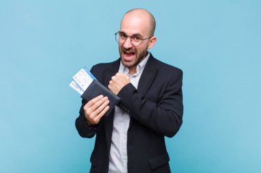 Genç kel adam mutlu, pozitif ve başarılı hissediyor, bir meydan okumayla karşılaştığında motive oluyor veya iyi sonuçları kutluyor.