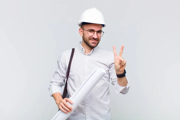 Jonge Kale Man Lacht Ziet Vriendelijk Uit Toont Nummer Twee — Stockfoto