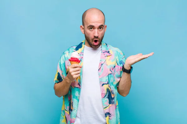 Jovem Careca Olhando Surpreso Chocado Com Mandíbula Caiu Segurando Objeto — Fotografia de Stock