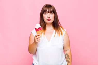 Artı cüsseli bir kadın üzgün, üzgün ya da kızgın ve olumsuz bir tavır takınıyor, anlaşmazlık içinde kaşlarını çatıyor.