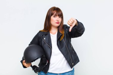 Artı boyut olarak, kızgın, sinirli, hayal kırıklığına uğramış ya da hoşnutsuz hisseden, ciddi bir bakışla başparmağını kaldıran bir kadın.