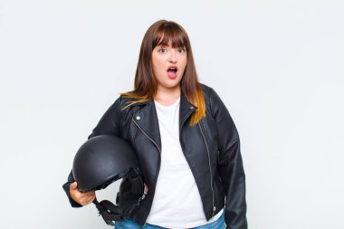 Artı boyunda bir kadın şok olmuş ya da şaşırmış görünüyor, ağzı açık bir şekilde 