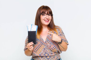 Artı boyda bir kadın heyecanlı ve şaşırmış görünüyor. Yan tarafı işaret ediyor ve yukarı doğru uzayı kopyalıyor.