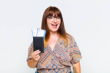 Artı cüsseli bir kadın mutlu ve hoş bir şekilde şaşırmış görünüyor. Büyülenmiş ve şok olmuş bir ifadeyle heyecanlanıyor.