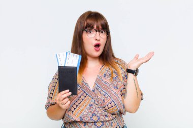 Artı boyut kadın şaşırmış ve şok olmuş görünüyor, çenesi düşmüş, bir objeyi elinde açık bir elle tutuyor.