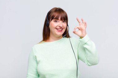 Artı cüsseli bir kadın mutlu, rahat ve tatmin olmuş hissediyor, iyi bir jestle onaylıyor, gülümsüyor