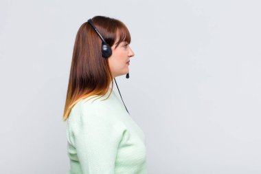 Artı profil görünümündeki boyutu olan kadın ilerideki boşluğu kopyalamak istiyor, düşünüyor, hayal ediyor ya da hayal ediyor.