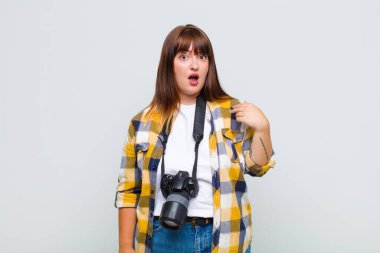 Artı, ağzı açık, kendini işaret eden, şok olmuş ve şaşırmış görünen bir kadın.