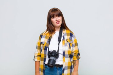 plus size woman feeling puzzled and confused, with a dumb, stunned expression looking at something unexpected