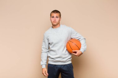 Genç sarışın adam üzgün ve mızmız, mutsuz bir bakışla, negatif ve hayal kırıklığına uğramış bir tavırla ağlıyor.