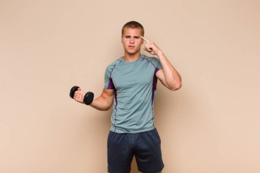 Genç sarışın adam şaşkın ve şaşkın hissediyor. Deli, deli ya da aklını kaçırmış olduğunu gösteriyor.