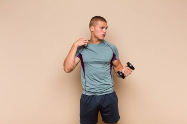 Genç, sarışın bir adam stresli, endişeli, yorgun ve hayal kırıklığına uğramış, gömleğini çekiştirmiş, sorunlu görünüyor.