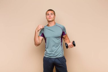 Genç sarışın adam kibirli, başarılı, pozitif ve gururlu görünüyor.