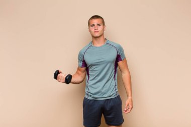 Genç sarışın adam üzgün, üzgün ya da kızgın ve olumsuz bir tavır takınıyor, anlaşmazlık içinde kaşlarını çatıyor.