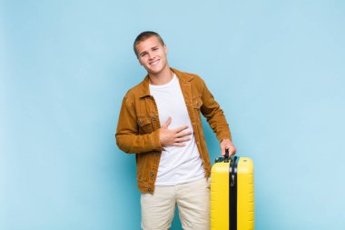 Genç sarışın adam komik bir şakaya yüksek sesle gülüyor, mutlu ve neşeli hissediyor, eğleniyor.