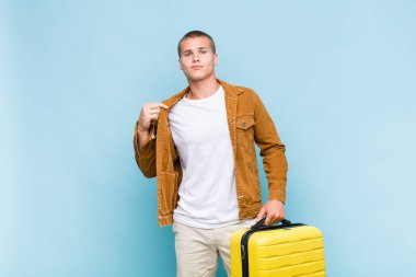 Genç sarışın adam kibirli, başarılı, pozitif ve gururlu görünüyor.