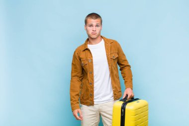 Genç sarışın adam üzgün ve mızmız, mutsuz bir bakışla, negatif ve hayal kırıklığına uğramış bir tavırla ağlıyor.