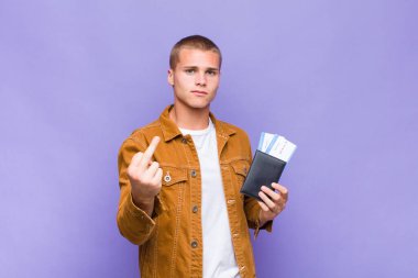 Genç sarışın adam kızgın, sinirli, isyankar ve agresif orta parmağını sallayarak karşılık veriyor.