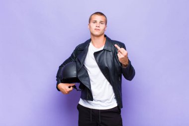 Genç sarışın adam kızgın, sinirli, isyankar ve agresif orta parmağını sallayarak karşılık veriyor.