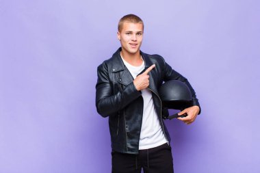 Genç sarışın adam heyecanlı ve şaşırmış görünüyor. Yana ve yukarı doğru uzayı gösteriyor.