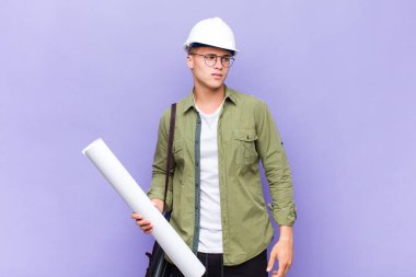 Genç sarışın adam üzgün, üzgün ya da kızgın ve olumsuz bir tavır takınıyor, anlaşmazlık içinde kaşlarını çatıyor.