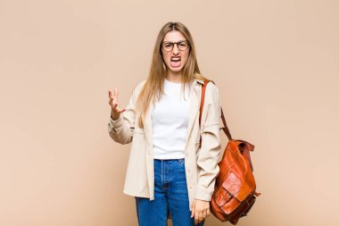 Sarışın, güzel bir kadın sinirli, sinirli ve sinirli görünüyor. 