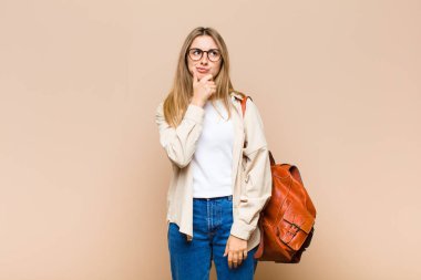 Sarışın, güzel bir kadın. Düşünüyor, kuşkulu ve kafası karışık. Farklı seçenekleri var.