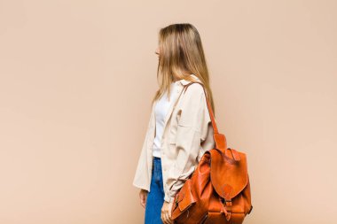 Profil görünümlü sarışın güzel kadın ileriyi kopyalamak istiyor, düşünüyor, hayal ediyor ya da hayal kuruyor.