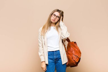 Yorucu, sıkıcı ve sıkıcı bir görevin ardından sıkılmış, hayal kırıklığına uğramış ve uykulu hisseden sarışın güzel bir kadın.