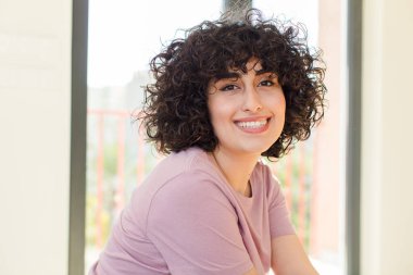 Genç ve güzel bir kadın yeni evinde rahatça oturuyor.