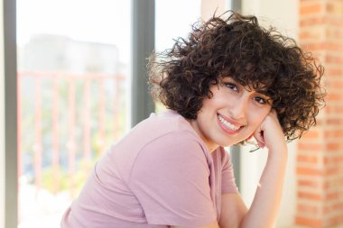 Genç ve güzel bir kadın yeni evinde rahatça oturuyor.