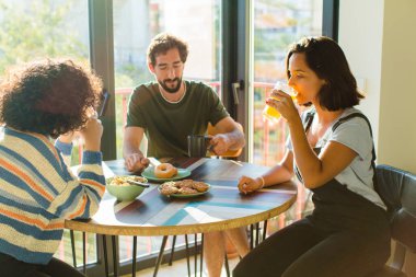 Bir grup arkadaş yeni evlerinde kahvaltı ediyorlar.