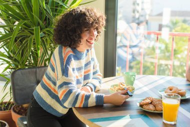 Bir grup arkadaş yeni evlerinde kahvaltı ediyorlar.