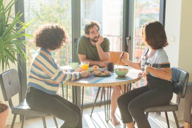 Bir grup arkadaş yeni evlerinde kahvaltı ediyorlar.