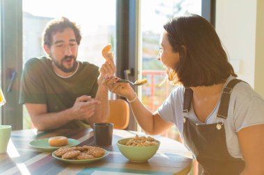 Bir grup arkadaş yeni evlerinde kahvaltı ediyorlar.