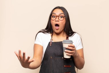 Genç Latin kadın ağzı açık ve şaşırmış, şok olmuş ve hayrete düşmüş inanılmaz bir sürprizle