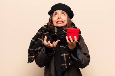 Genç ve güzel bir kadın elinde bir hediye tutuyor.