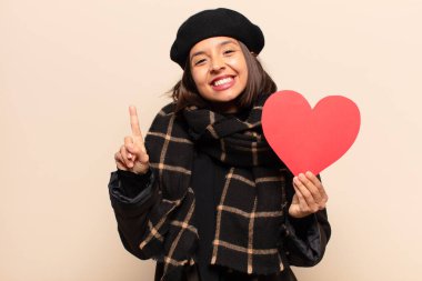 Genç ve güzel bir kadın elinde kalp kartı tutuyor.