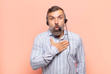 Yetişkin yakışıklı bir adam şaşkın ve şaşırmış hissediyor, gülümsüyor, el ele tutuşuyor, o olmaktan mutlu ya da minnettarlık gösteriyor.