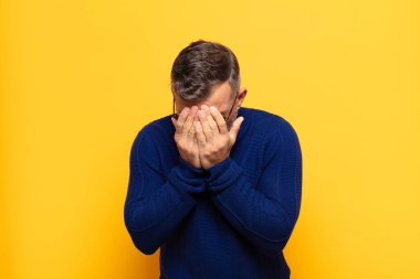 Yetişkin, yakışıklı bir adam üzgün, hayal kırıklığına uğramış, gergin ve depresif. İki eliyle yüzünü kapatıyor, ağlıyor.