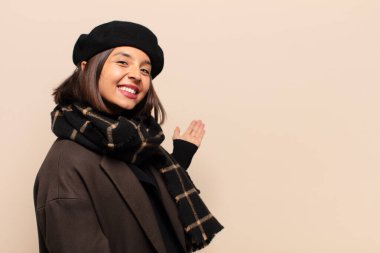 İspanyol kadın kendini mutlu ve neşeli hissediyor, gülümsüyor ve seni hoş karşılıyor, seni dostça bir jestle içeri davet ediyor.