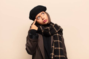 Dikkatle bakan İspanyol kadın, şüpheli bir ifadeyle merak ediyor, yukarı ve yana bakıyor