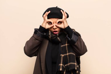 İspanyol kadın şaşkın, şaşkın ve şaşırmış hissediyor, elinde şaşkın, inançsız bir bakışla gözlük tutuyor.