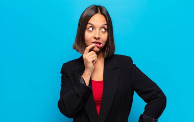 Şaşırmış, gergin, endişeli ya da korkmuş bakışları olan İspanyol bir kadın kopya boşluğuna doğru bakıyor.