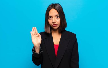 İspanyol kadın ciddi, sert, hoşnutsuz ve kızgın görünüyor. Avuç içinin açık olması jesti durduruyor.