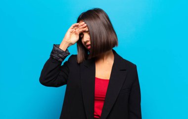 İspanyol kadın stresli, yorgun ve hayal kırıklığına uğramış görünüyor, alnından ter damlıyor, umutsuz ve bitkin hissediyor.