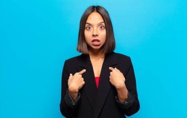 İspanyol kadın şok olmuş ve şaşırmış görünüyor, ağzı açık, kendini işaret ediyor.