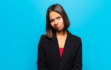 Hispanik kadın kendini şaşkın ve şüpheli hissediyor, merak ediyor ya da karar vermeye çalışıyor.