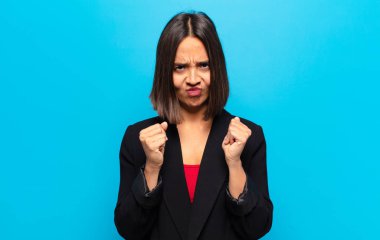 İspanyol kadın kendinden emin, sinirli, güçlü ve agresif görünüyor. Yumrukları boks pozisyonunda dövüşmeye hazır.